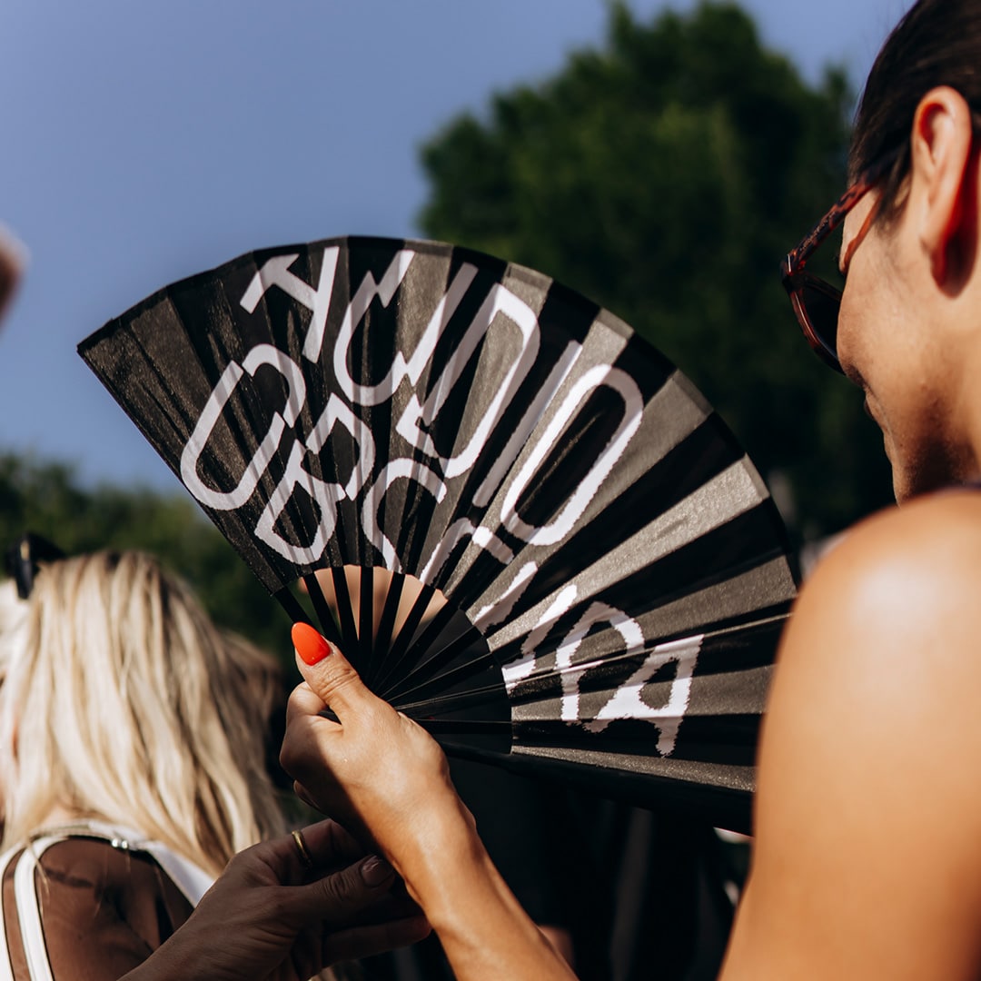 Logo Audio Obscura op een waaier van een festivalganger