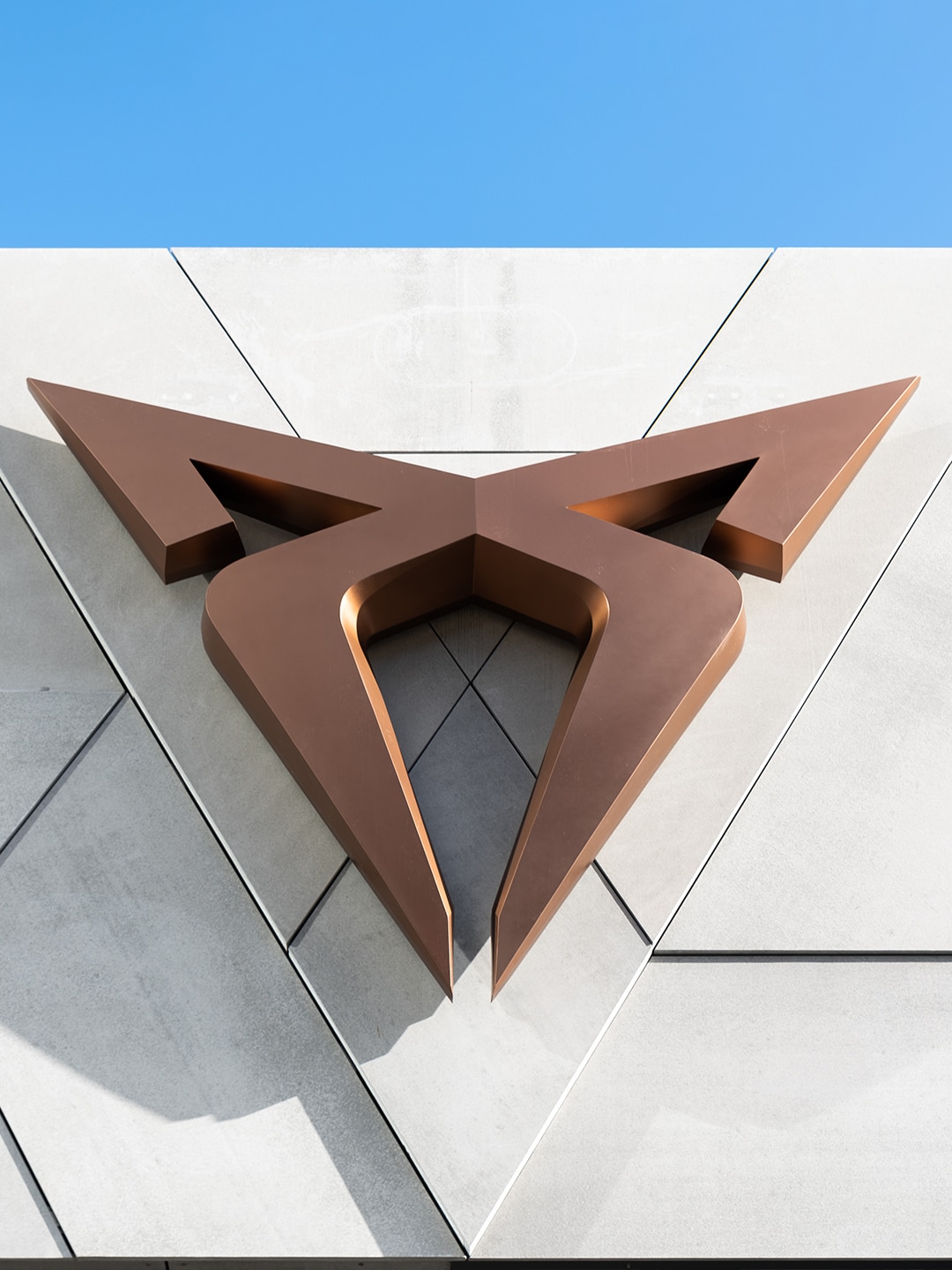 CUPRA logo op een gebouw, met blauwe lucht erboven