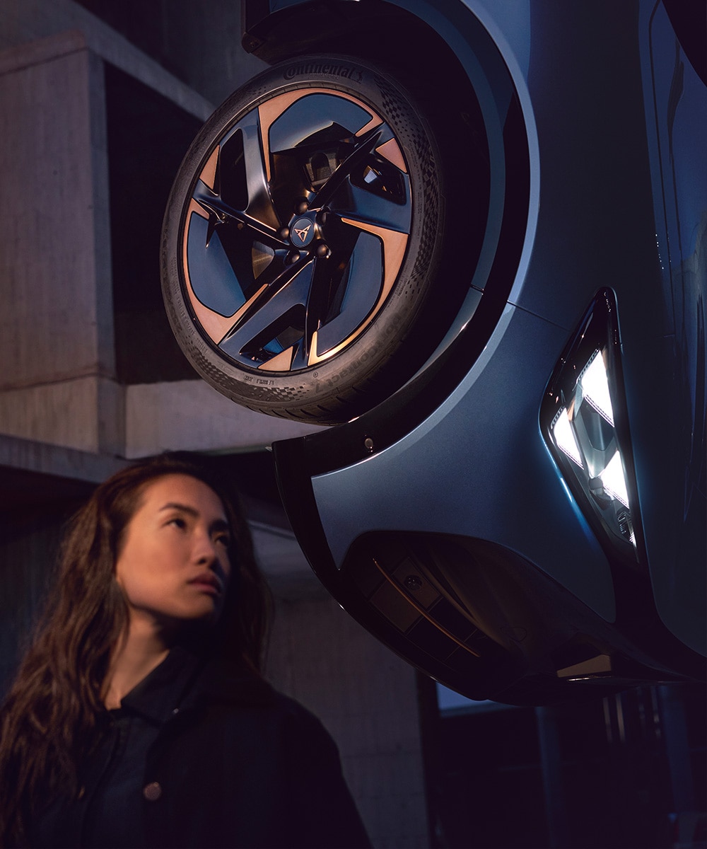 vrouw kijkt naar de velg van een cupra tavascan