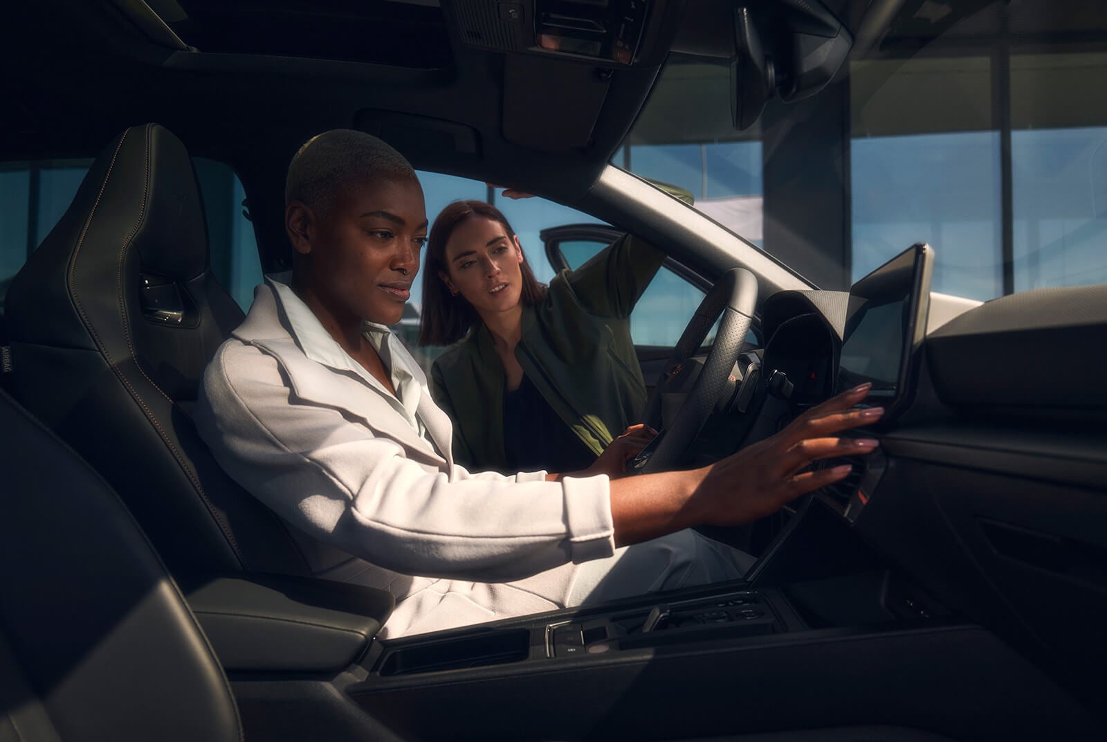 Twee vrouwen die lachend in een CUPRA zitten