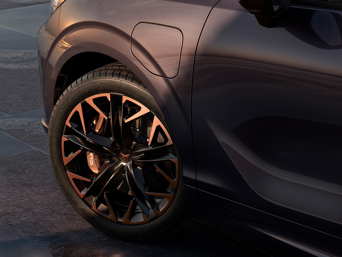 Zijaanzicht van de CUPRA Terramar met maximale remkracht, geparkeerd aan de kust, met de nadruk op de Dark Void-lak en de 20 inch Hadron Copper lichtmetalen velgen.