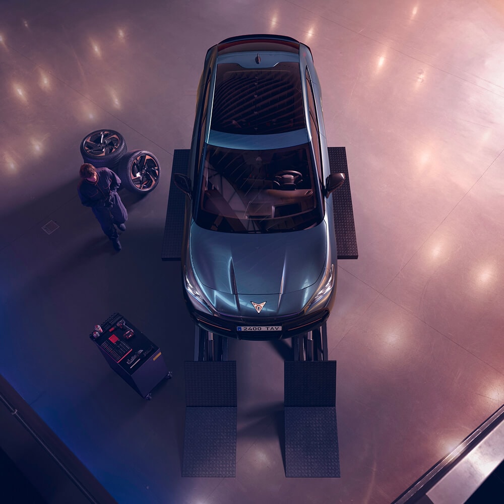 CUPRA Tavascan in een werkplaats met monteurs er omheen