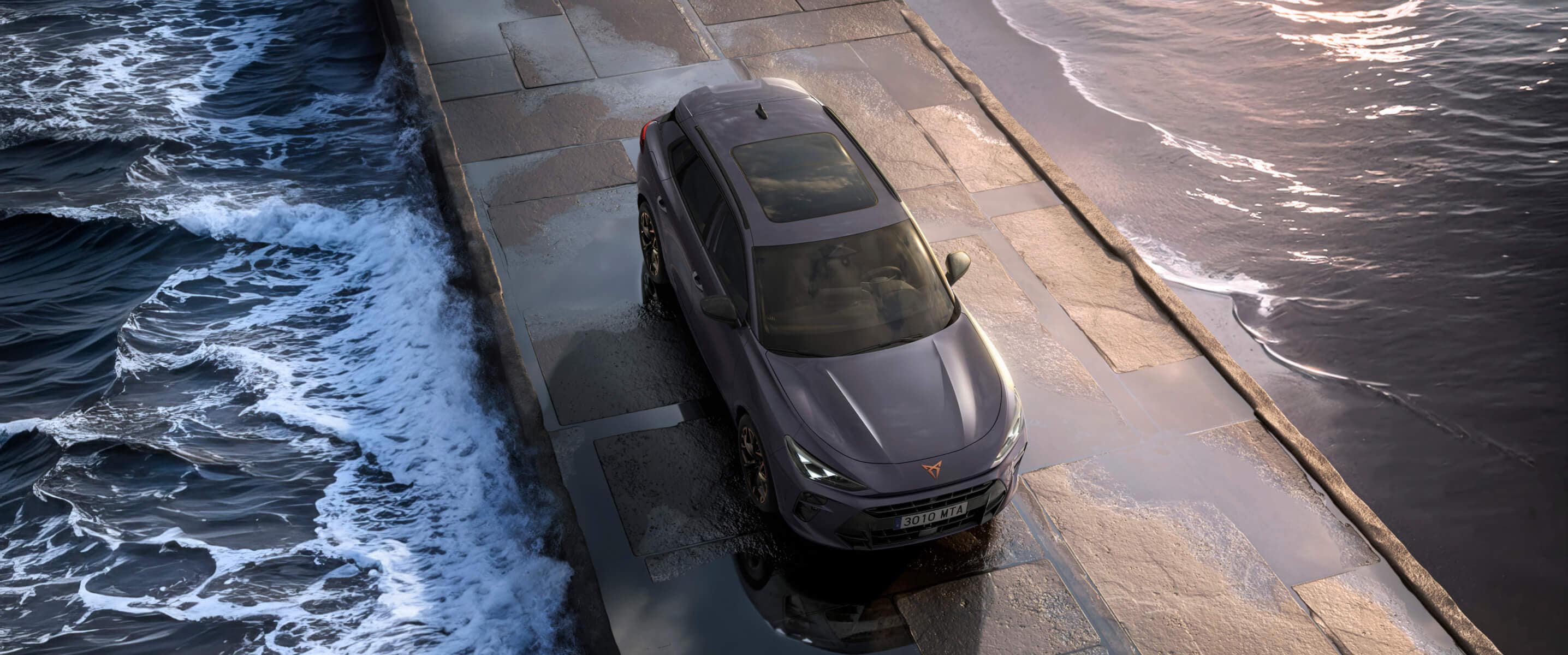 De CUPRA Terramar 2025 hybride SUV op een nat wegdek aan zee, met strakke koplampen, moderne lichtmetalen velgen en een op een haai geïnspireerd frontdesign.